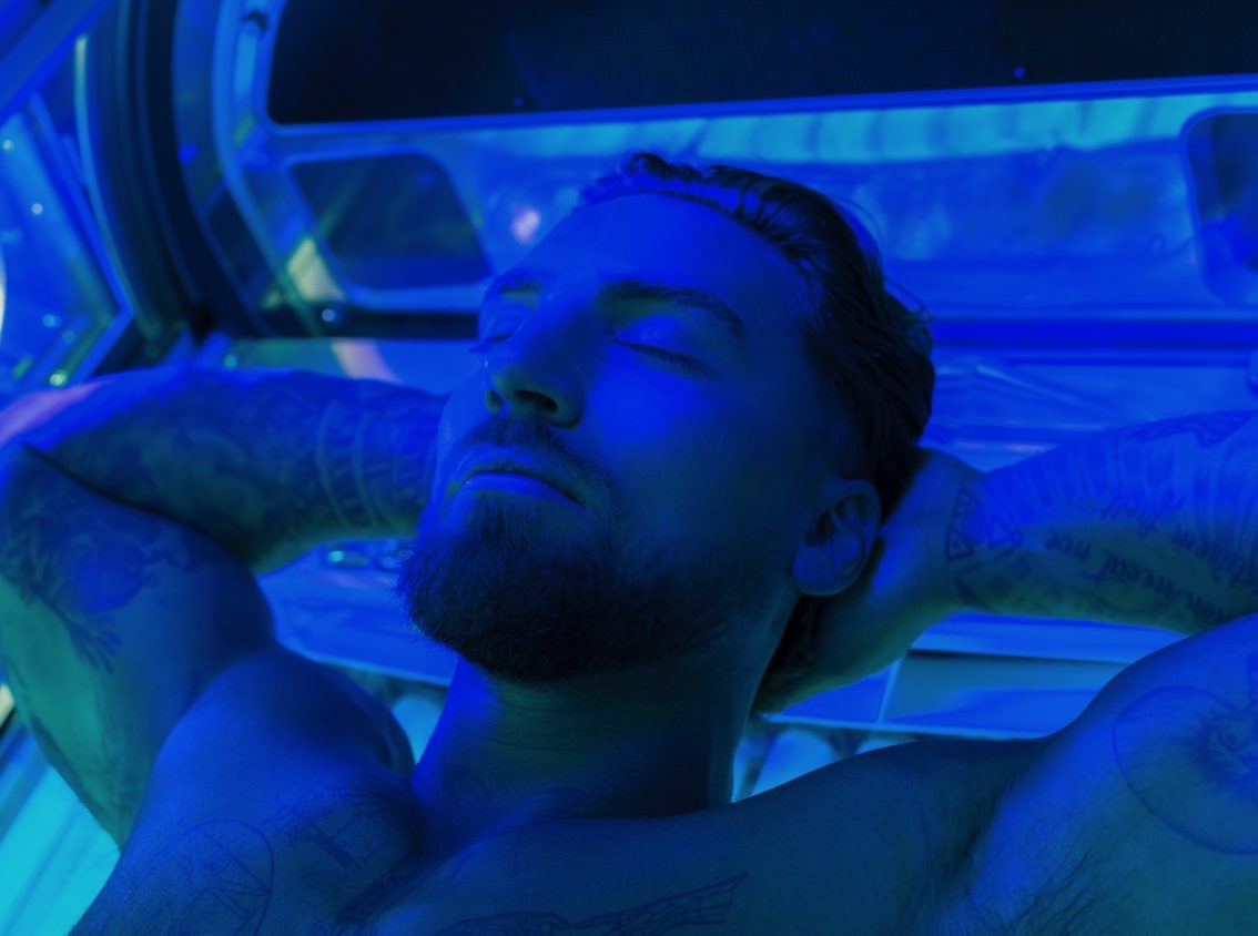 man lying on sunbed with eyes closed