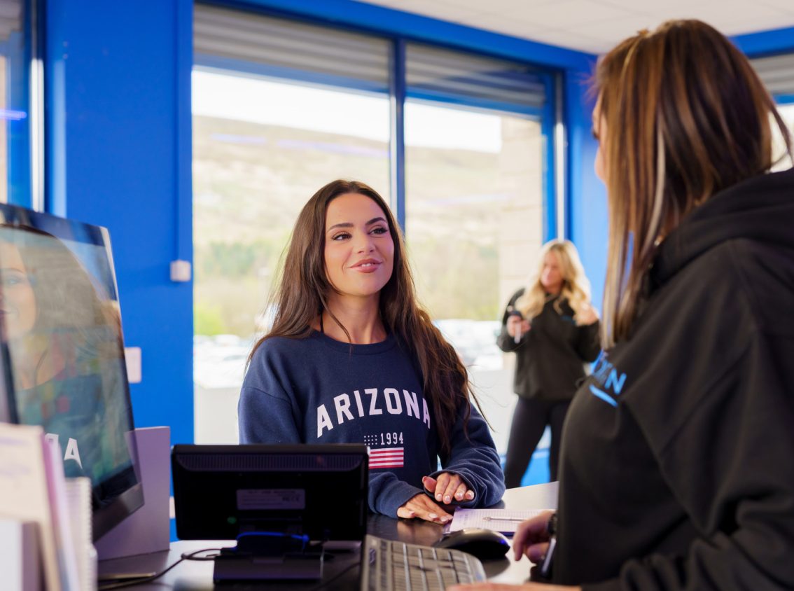 woman at customer service counter smiling whilst being served