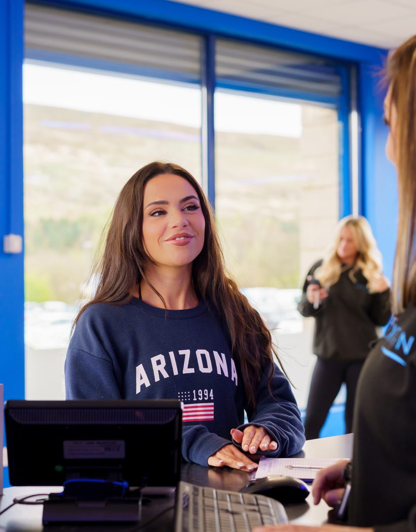 woman at customer service counter smiling whilst being served